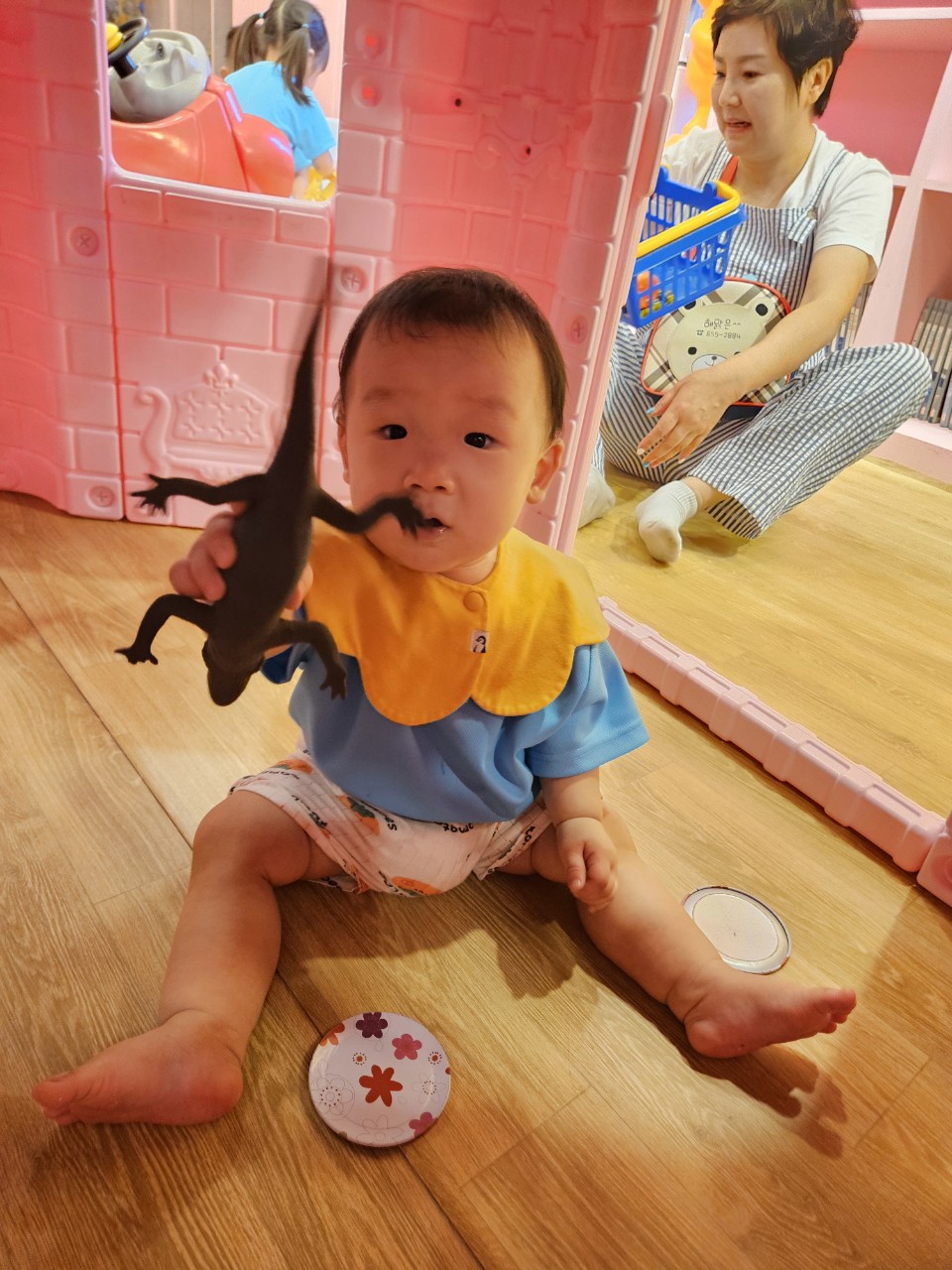 도마뱀 장난감 들고 선생님에게 보여주고 있는 11개월 아기