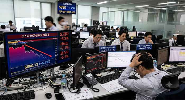 급락하는 주가 차트와 머리를 감싸 쥔 증권사 트레이더들.