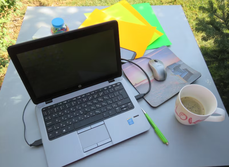 노트북과 커피가 놓인 야외 테이블, 감정 정리나 글쓰기를 위한 차분한 작업 공간