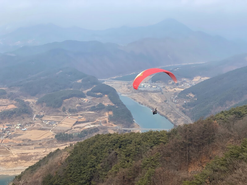 단양에서-패러글라이딩을-하는-사람들-아래-강이-보임