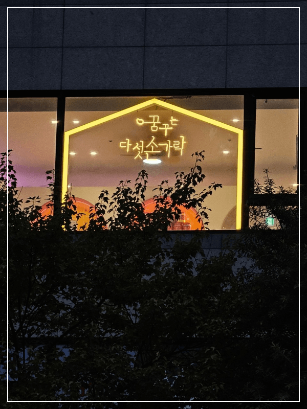 용인-동백에-위치한-꿈꾸는-다섯손가락-키즈카페의-네온사인이-창문을-통해-보이는-모습,-밤에-따뜻한-분위기를-연출합니다.