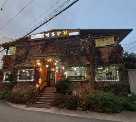 담쟁이덩굴과 전구 장식으로 운치 있는 분위기를 연출하는 아리곳간 전통찻집의 외부 전경