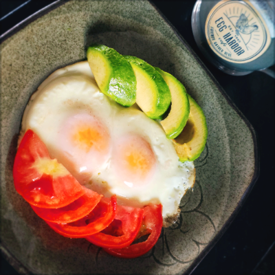 접시에 담긴 계란, 토마토 슬라이스, 아보카도.