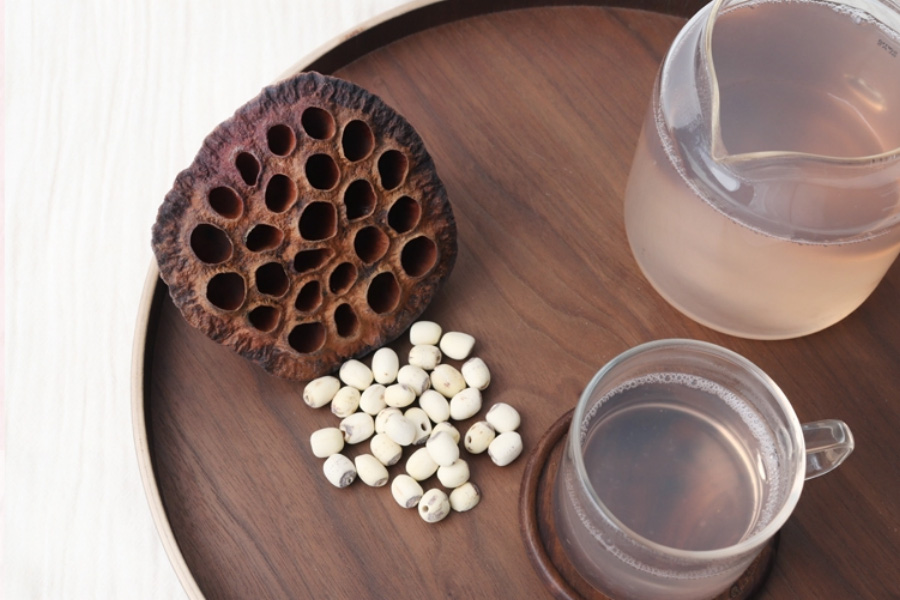 야생에서 채취를 한 연꽃의 씨를 껍질을 까서 하얀 알맹이만을 축출하여 하얀 바닥 위에 고동색의 동그란 쟁반 위에 놓아두고 그 옆에는 연꽃씨를 넣고 끓인 연꽃씨차를 가득 담은 투명한 유리주전자와 찻잔을 두고 찍은 사진