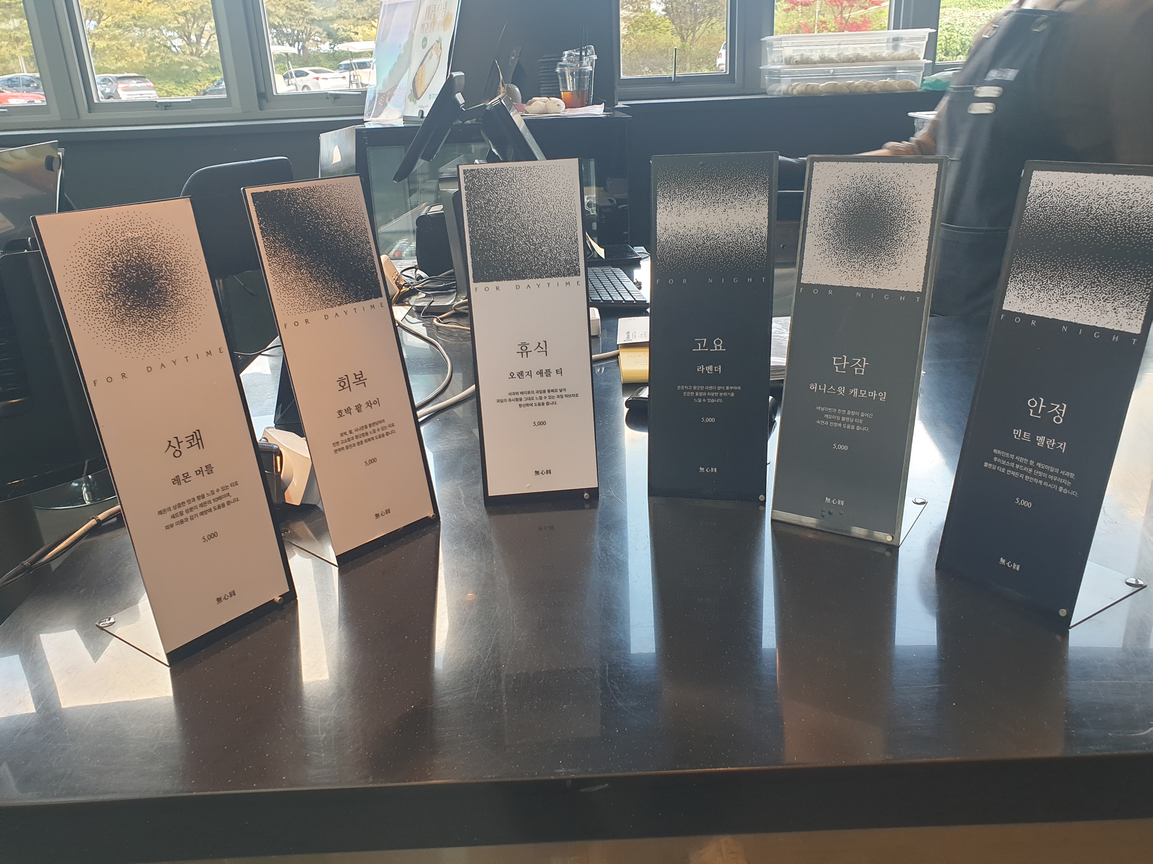 테이블 위에 작은 POP로 티 메뉴들이 써있다.