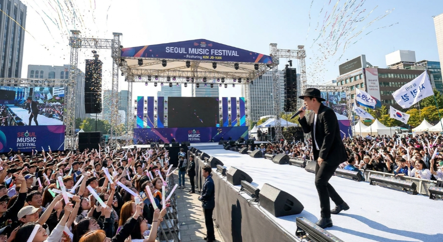 야외 무대에서 열정적으로 노래하는 가수와 환호하는 관객들의 열기 가득한 장면