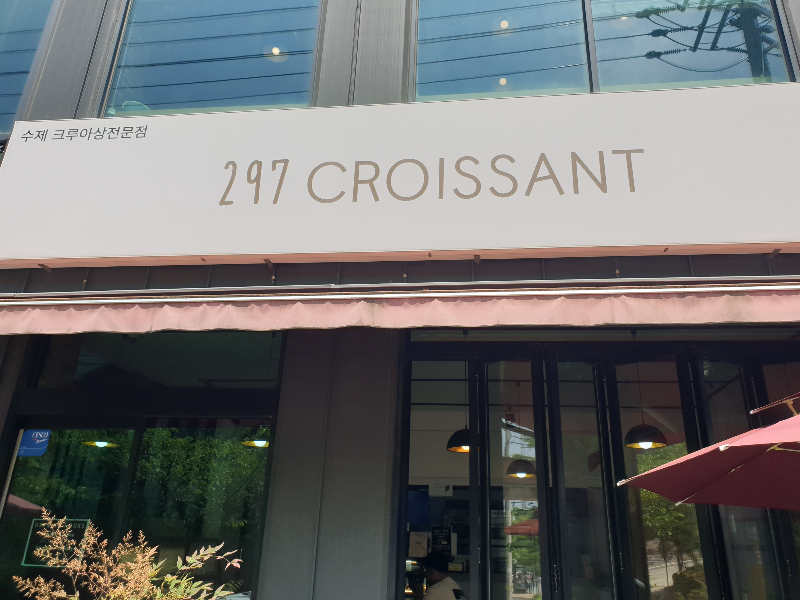 흰 바탕에 프린트된 297 CROISSANT 글자로 된 다소 밋밋한 간판
