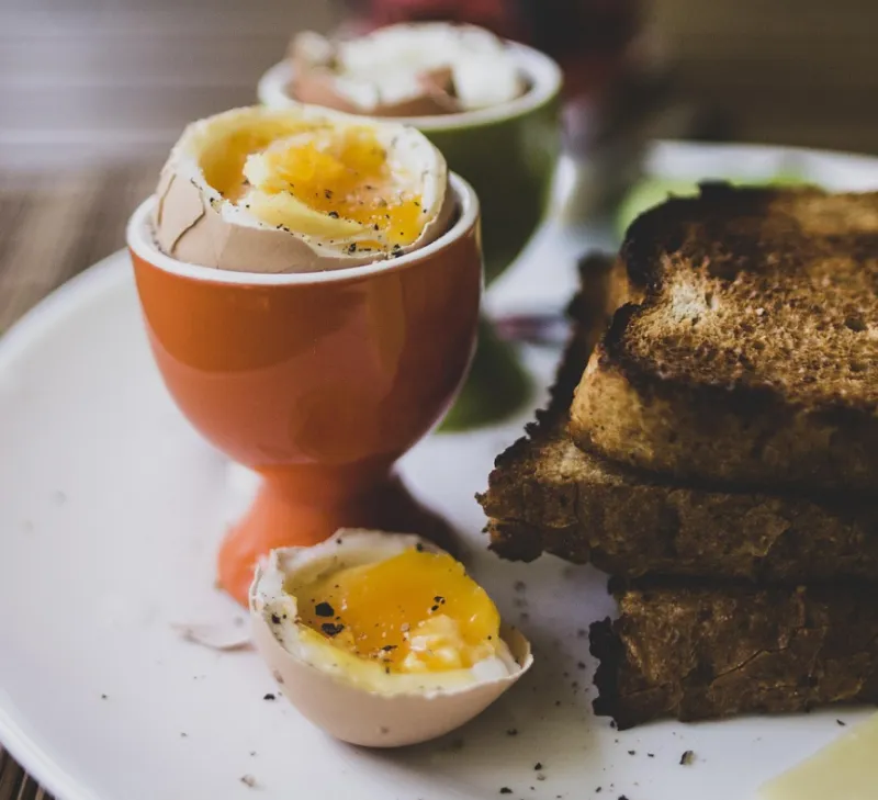 컵에 담긴 반숙달걀과 구워진빵