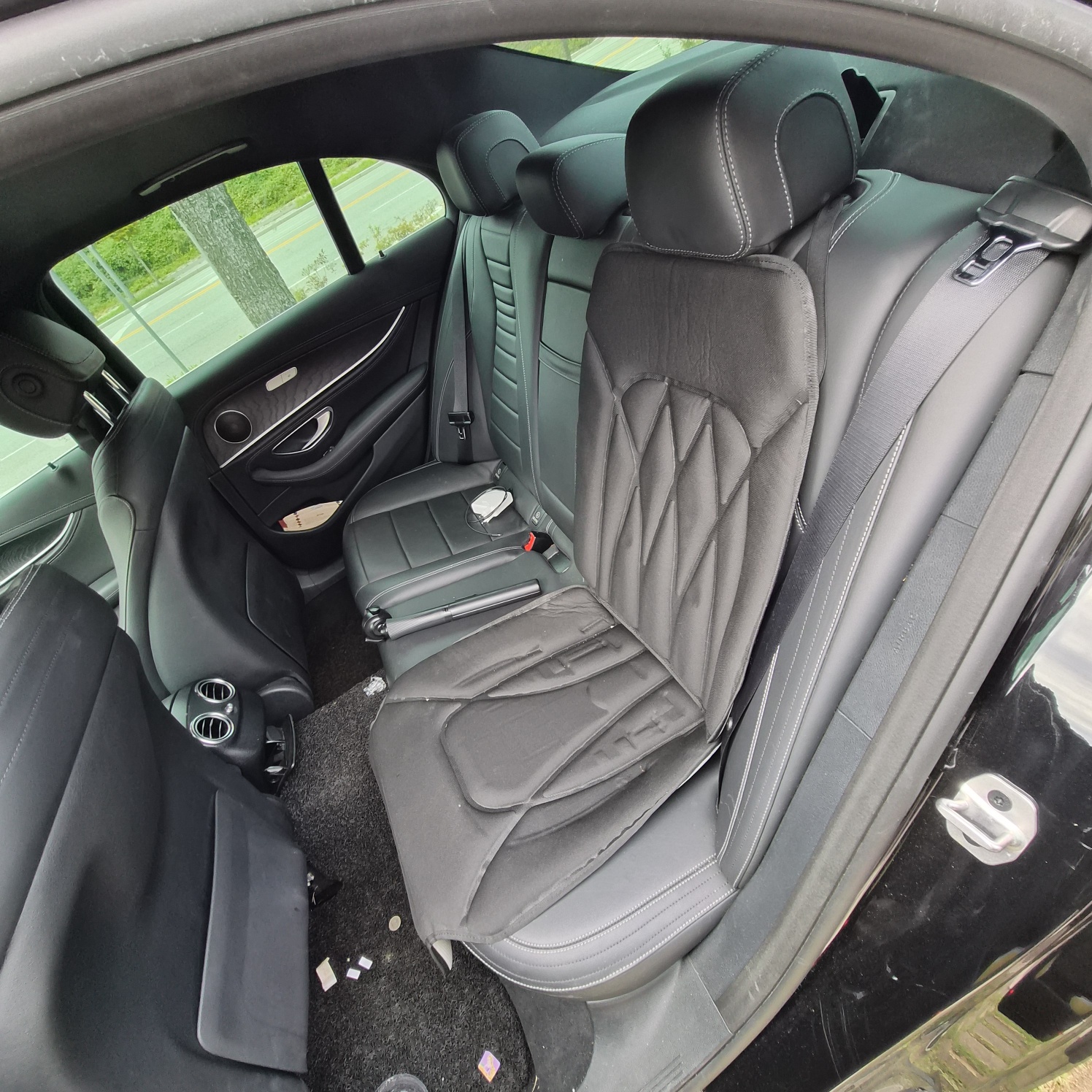 차량 뒷좌석에 블랙 컬러의 카시트 보호 매트가 완전히 설치