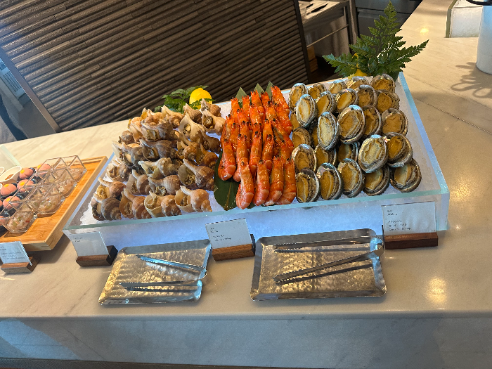 큰 접시 위에 찐 소라, 새우, 전복이 올려져 있다