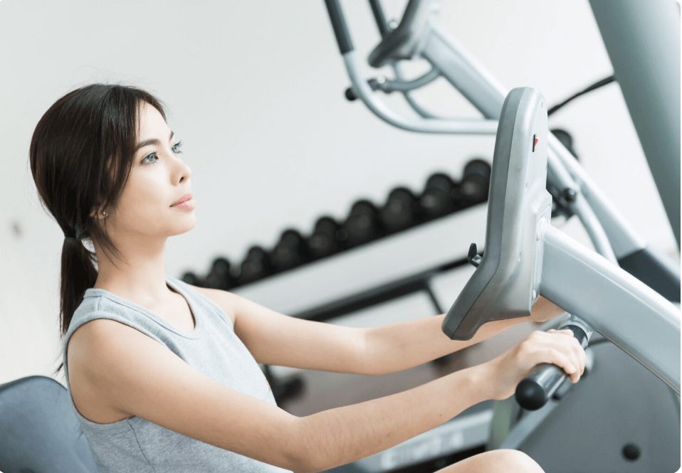 헬스장에서 자전거 운동하는 여성