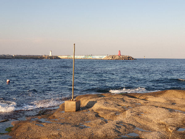바다 너머 등대가 보인다. 앞에는 바위가 있어 사진 찍기 좋다.