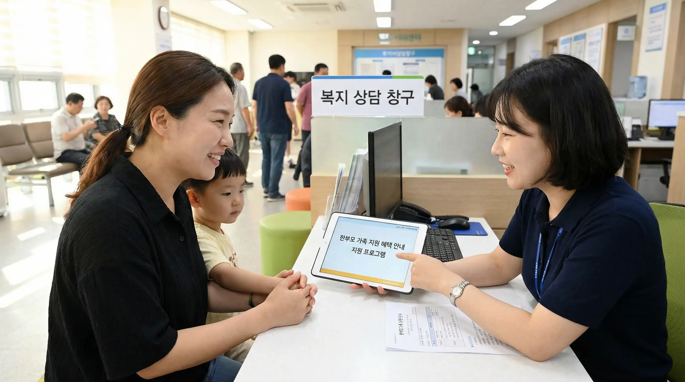 행정복지센터 창구에서 복지 공무원과 친절하게 상담하며 지원 혜택을 안내받는 한부모의 모습