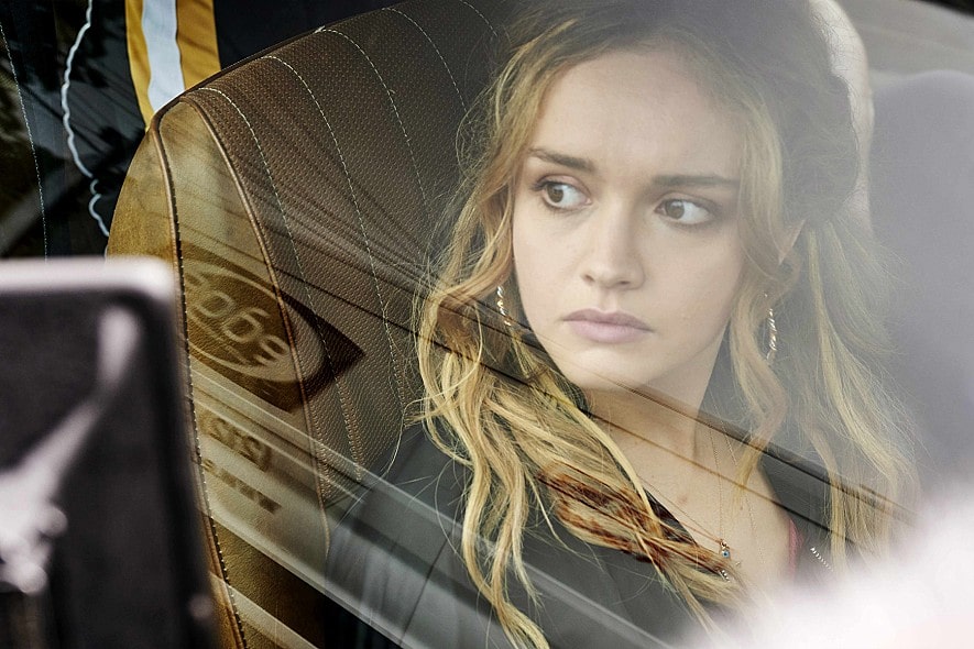 창밖을 내다보는 올리비아 쿡의 모습