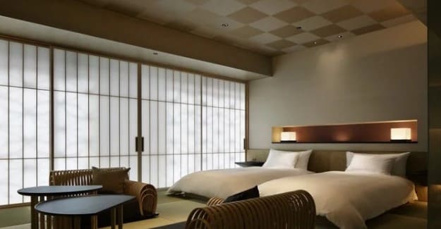 타다미가 깔려있고 보통 사이즈의 침대 2개와 테이블이 있는 실내