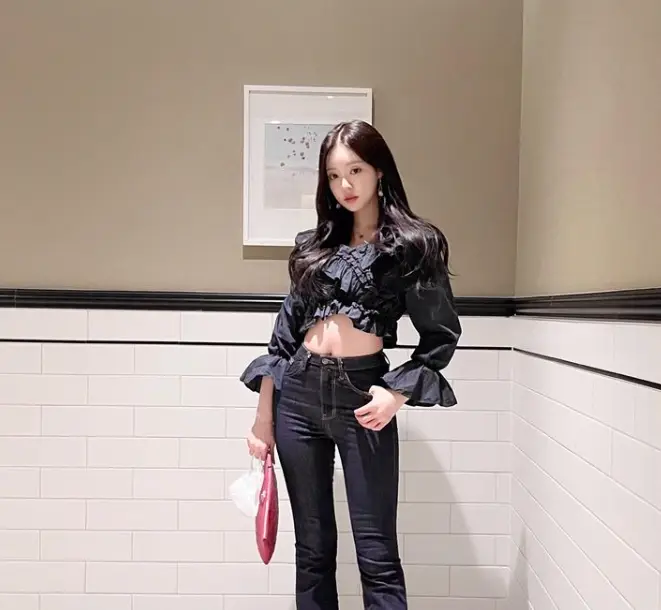 솔로지옥 3 - 검정색 바지에 검정색 긴팔 배꼽이 드러난 블라우스를 입고 분홍색 가방을 들고 긴머리를 풀고 앞을 바라보며 서있는 유시은