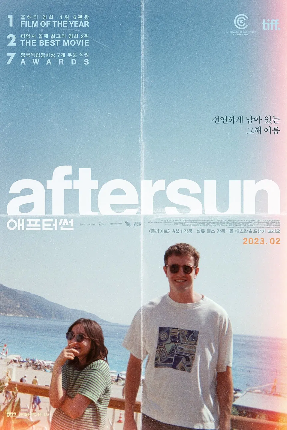 영화 <애프터썬> 포스터. 햇살 가득한 해변을 배경으로 딸과 아버지가 선글라스를 쓰고 함께 웃고 있다. 상단에는 '선연하게 남아 있는 그해 여름'이라는 문구가 적혀 있다.