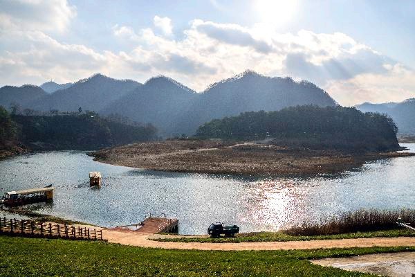 산앞에 강이 흐르고 배한척이 떠있다.