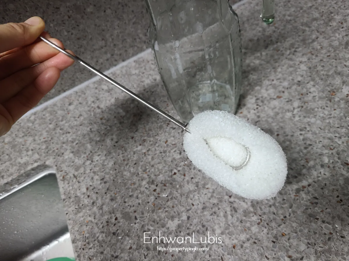 손으로-들고있는-스텐손잡이의-희색폼수세미병솔