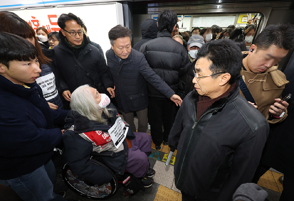 박경석 전국장애인차별철폐연대 대표가 4일 오전 서울 종로구 서울지하철 4호선 혜화역에서 열린 출근길 선전전에서 역사 밖으로 강제퇴거를 당하고 있다. [사진=뉴시스]