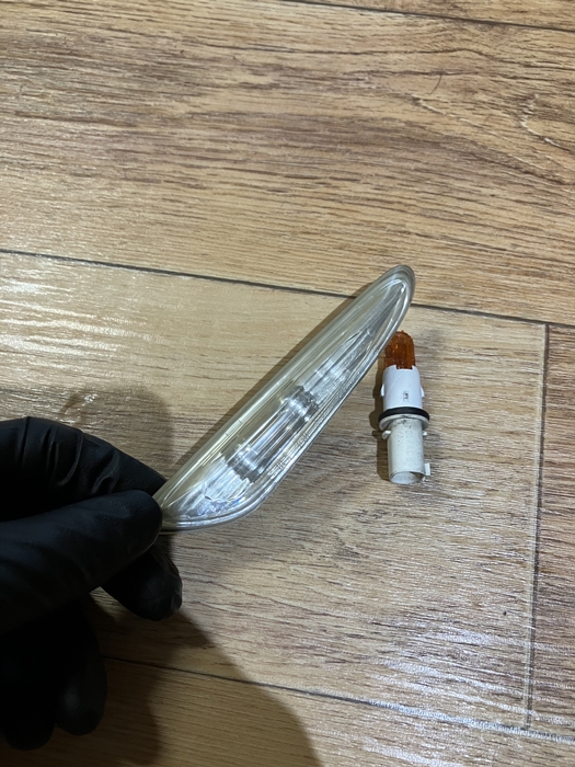 탈거된 자동차 사이드 마커와 분리된 전구 벌브를 바닥에 놓고 촬영한 사진