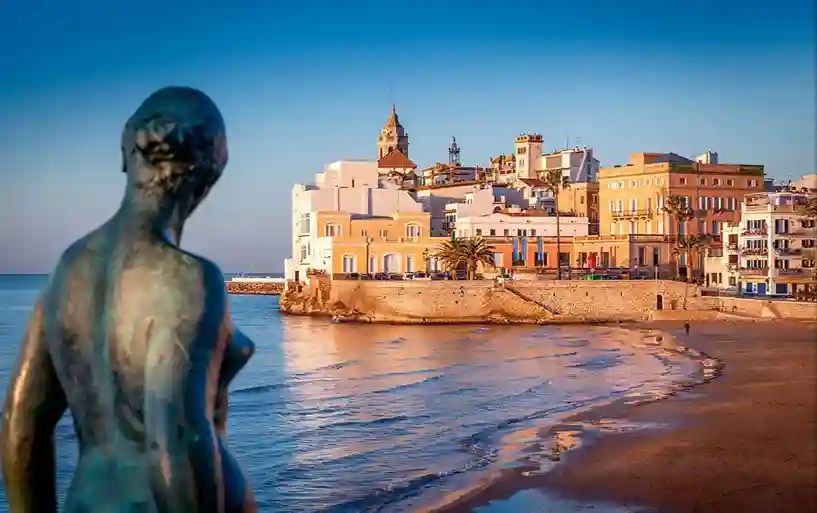 스페인 시체스 해변과 조각상 너머로 보이는 도시 전경, 몬세라트 버스투어 코스 중 한 장면