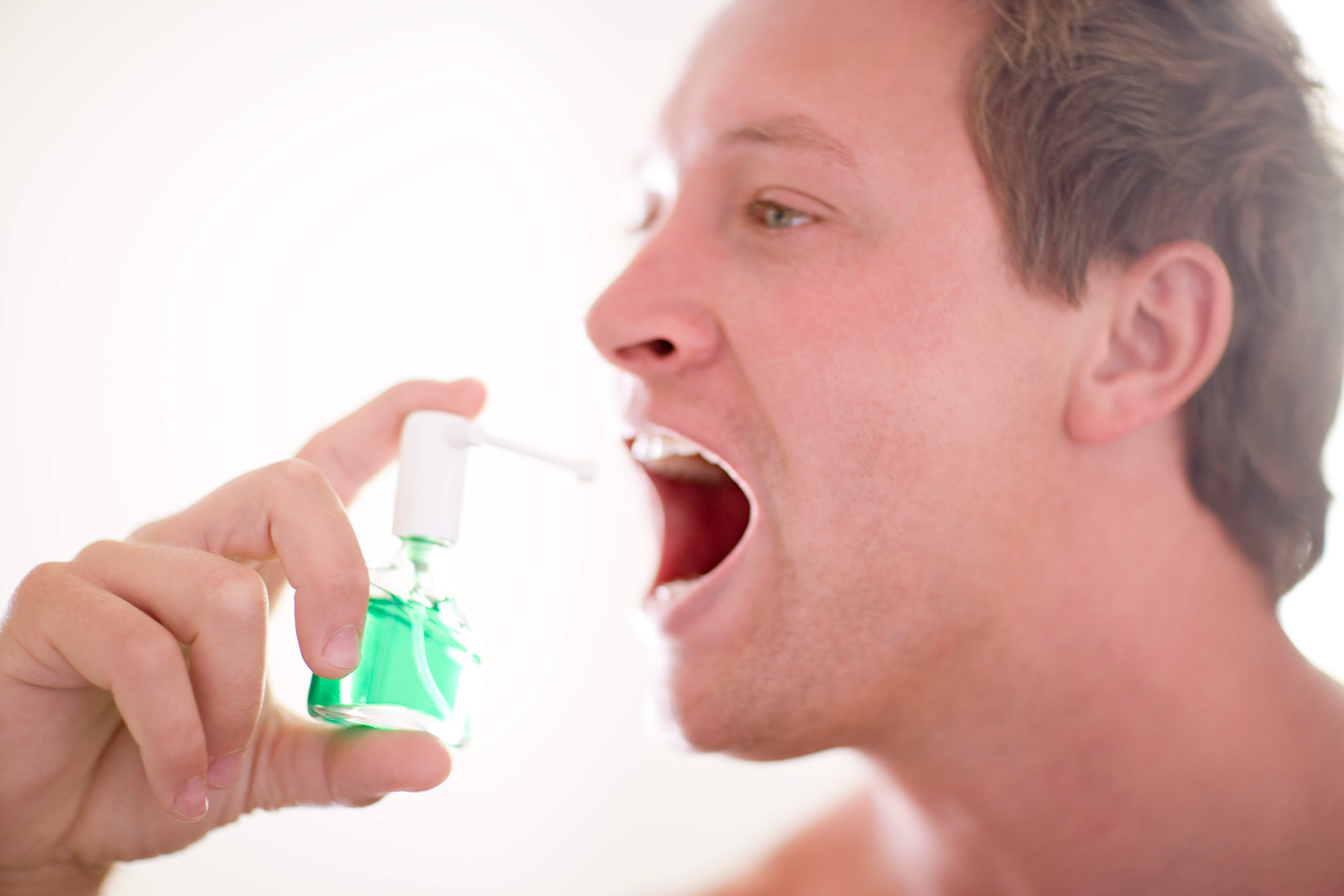 입 속에 가글을 뿌리는 남자