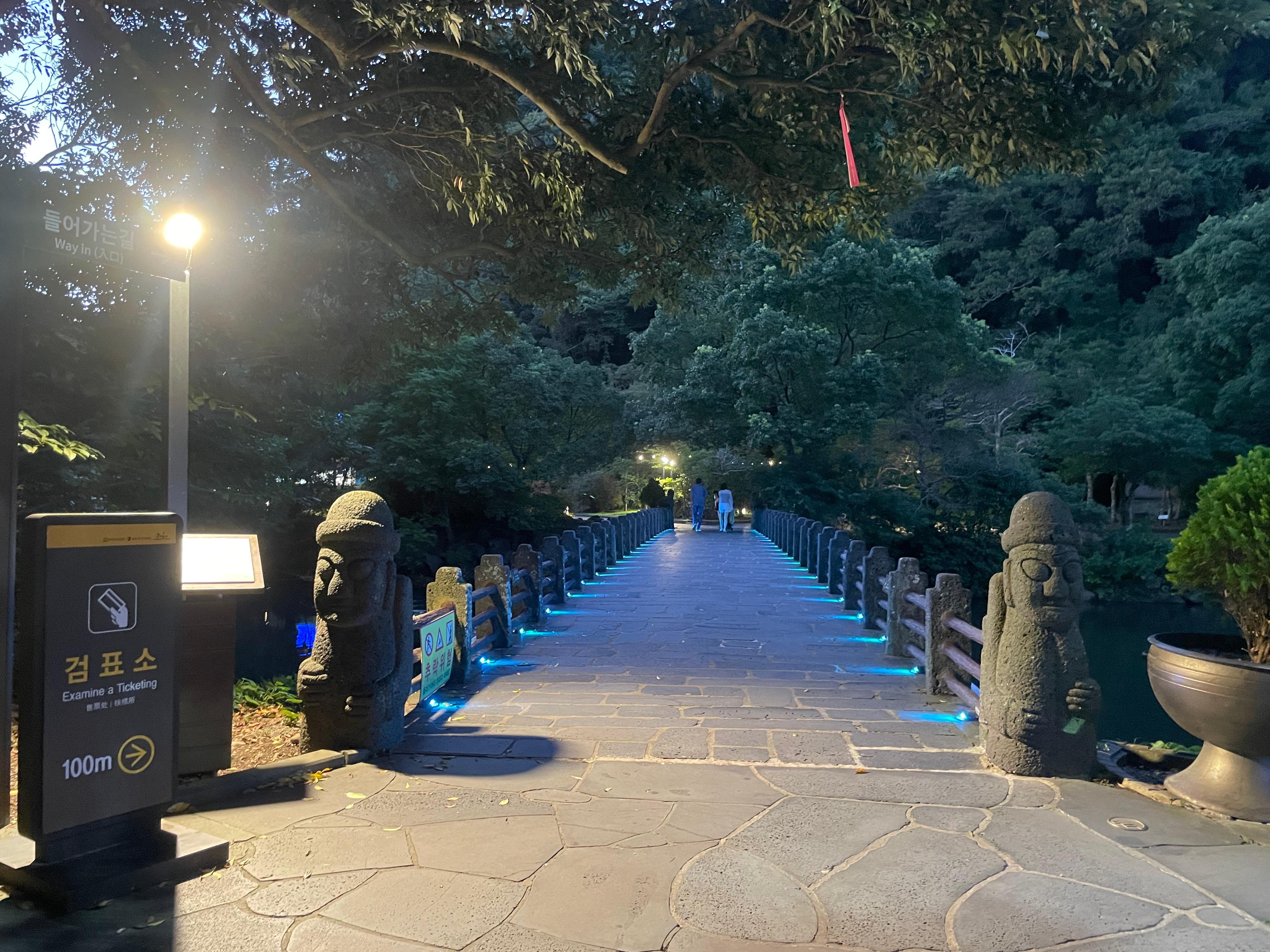 돌하르방과 푸른 조명이 있는 다리를 건너 검표소로 향한다