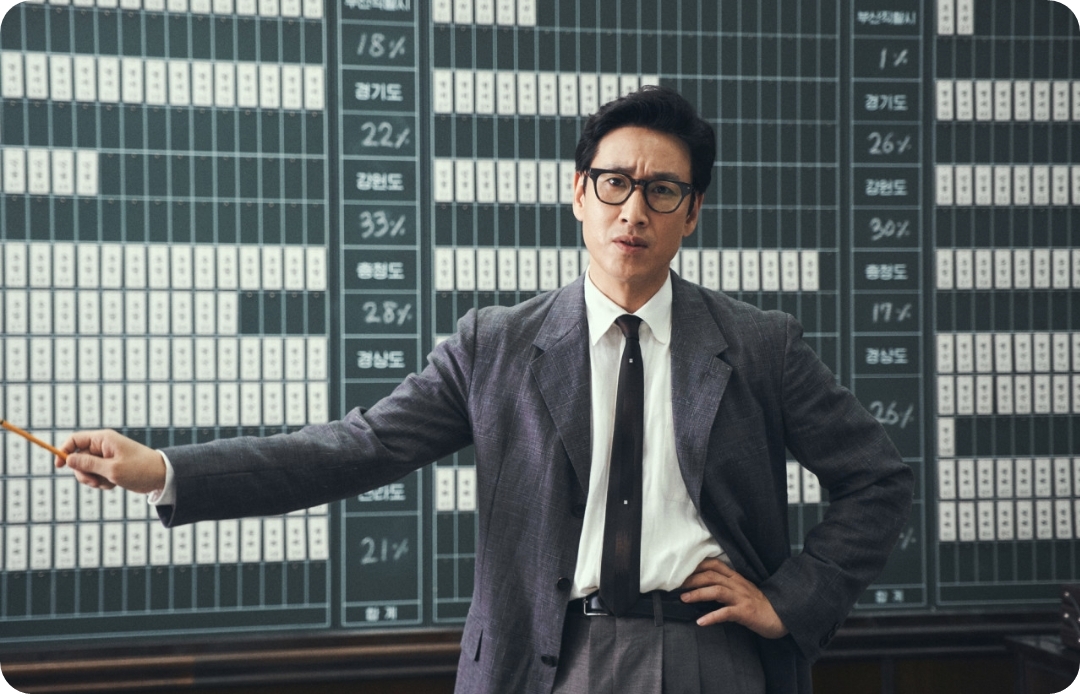 볼펜을 들고 무언가를 설명하는 안경낀 남자 사진