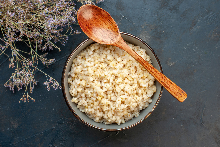 야생에서 체취를 한 보리와 쌀을 혼합하여 만든 보리밥을 동그란 그릇에 가득 담아둔 것을 검은 바닥 위에 놓아두고 나무숟가락과 들꽃으로 장식을 한 후에 찍은 사진