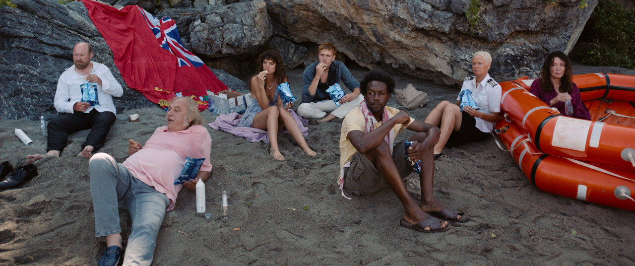 크루즈 전복 후 무인도에 생존한 8명이 물과 과자를 먹는 모습