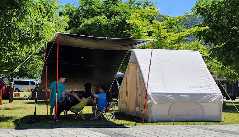 에어텐트에서 가족과 함께 캠핑 하는 사진