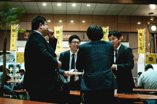 남자 넷이 양복을 입고 대화를 나누는 장면