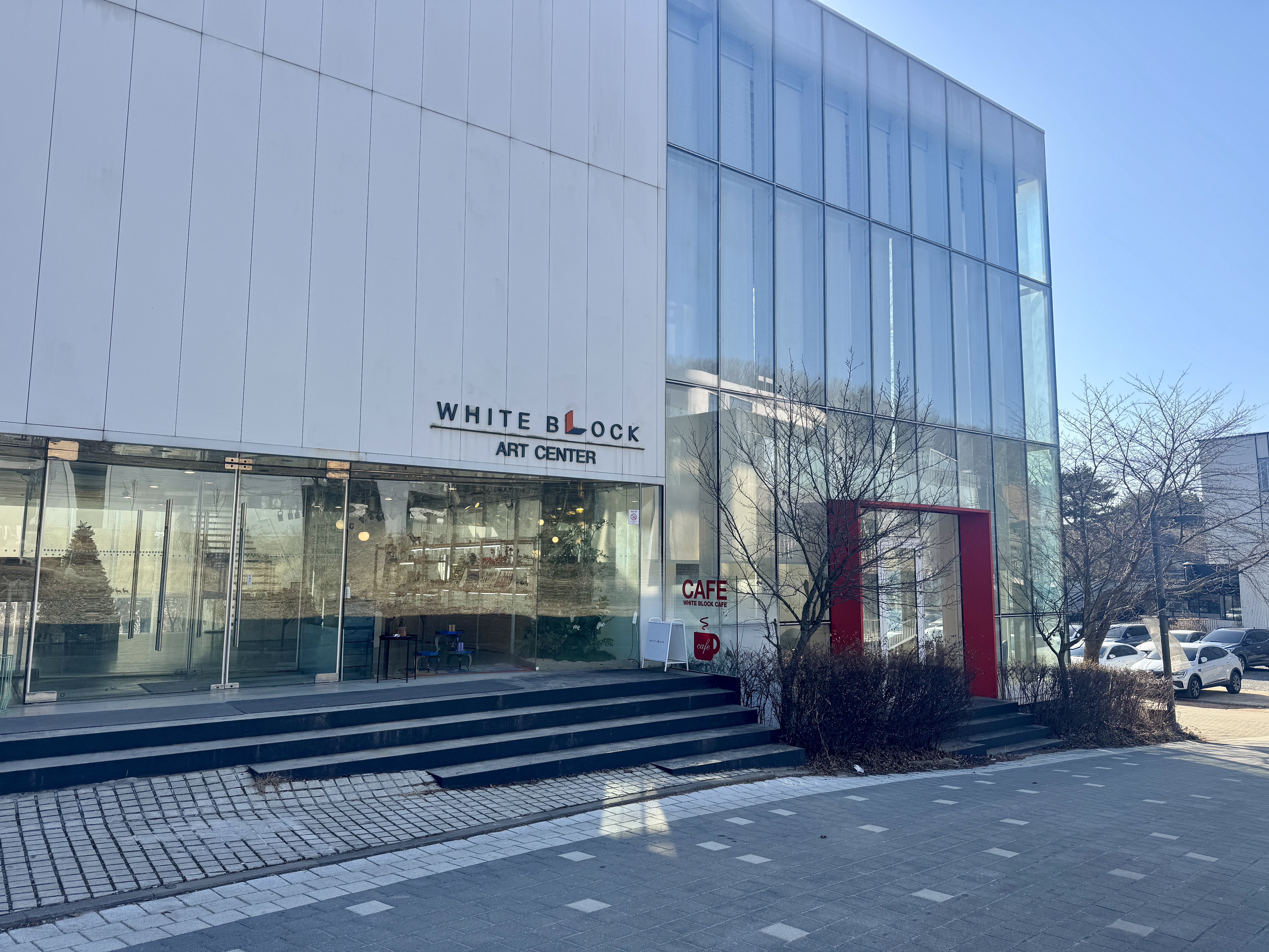 파주 헤이리 아트센터 화이트 블럭 외관, 화이트 톤의 통유리 건물과 카페 입구 전경