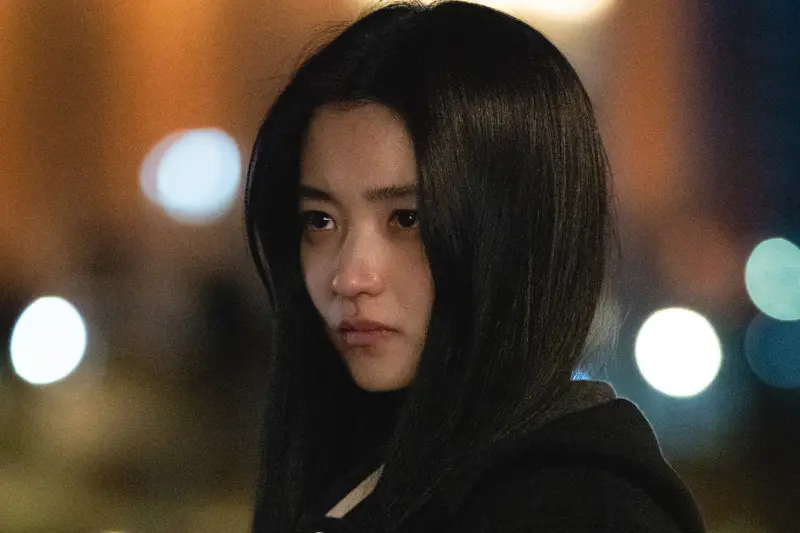 밤 도시를 배경으로 어딘가를 무표정으로 바라보는 구산영