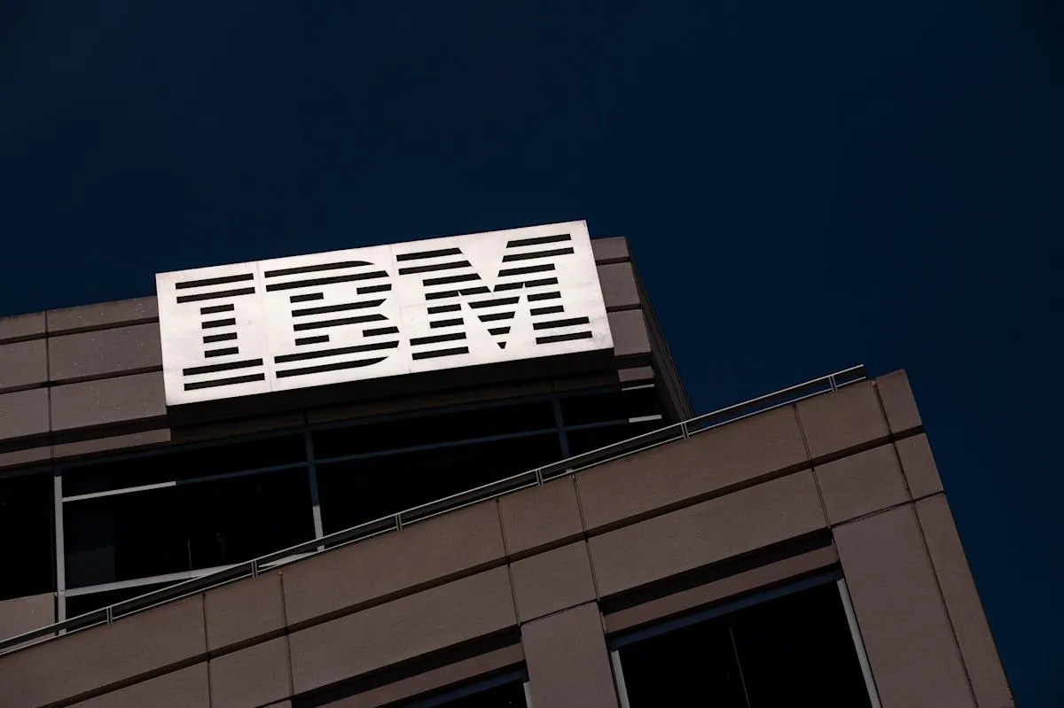 건물 상단에 설치된 IBM 로고 간판. 야간 또는 어두운 하늘을 배경으로 흰색 줄무늬 형태의 IBM 로고가 선명하게 보인다.