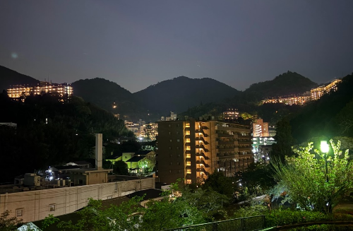 고베의 야경, 높은 건물들이 듬성듬성 보이고 저 멀리 산들이 보인다. 밤이라 건물들이 반짝반짝 하다.