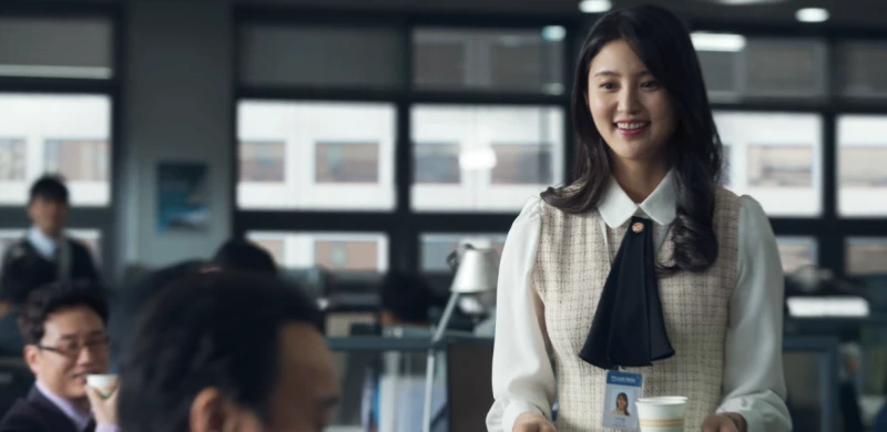 사무실을 배경으로 베이지색 정장을 입고 두손에는 믹스커피를 들고 있는 드라마 마스크걸의 이아름 캐릭터