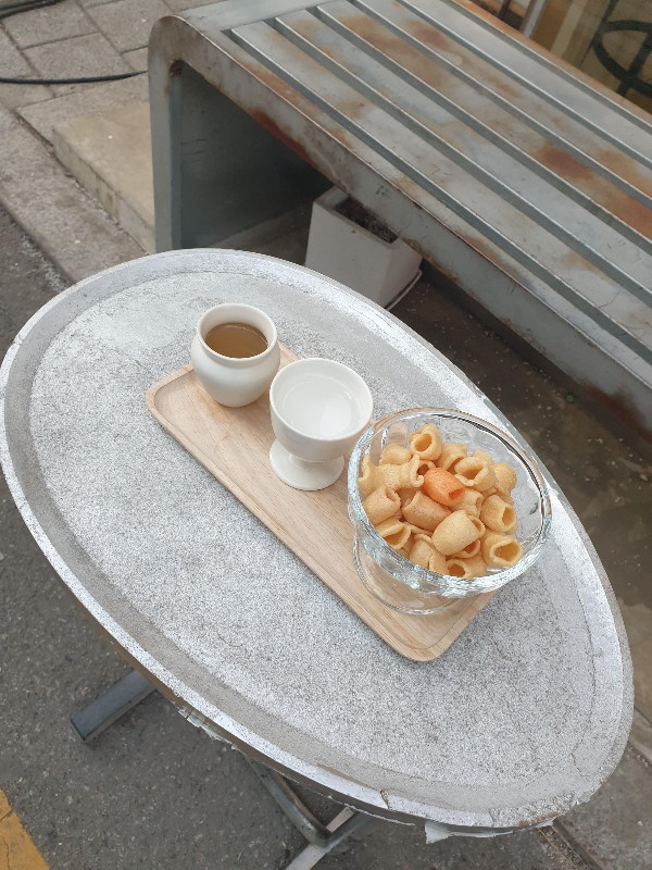 은색 테이블 위에 주문 한 잔 술 2잔이 올려져 있다. 서비스 뻥튀기도 나온다.