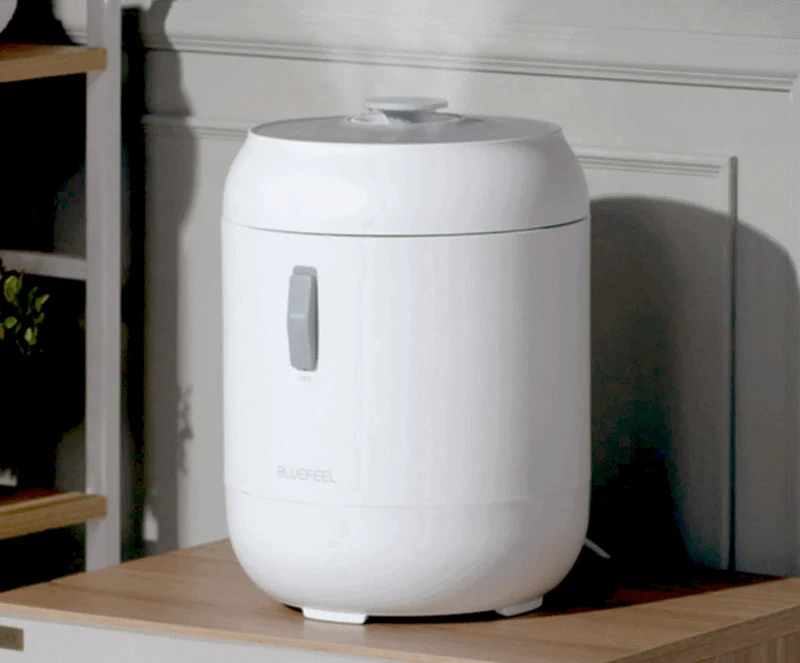 흰색 가습기가 탁자 위에 놓여있고, 하얀 수증기가 위로 올라오고 있다.