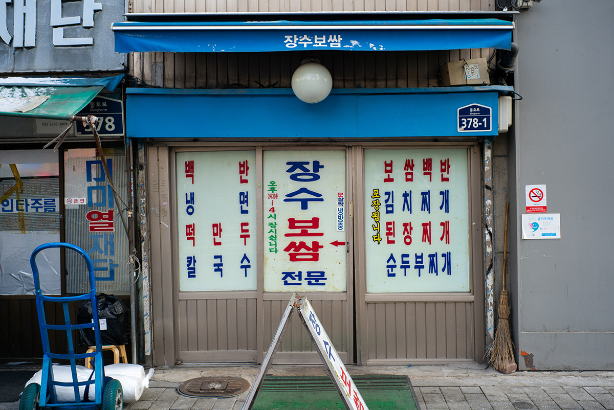 오래된 식당 간판과 유리창에 남은 색 바랜 페인트, 라이카 M-P Typ 240로 촬영한 차분한 블루 톤의 거리 풍경