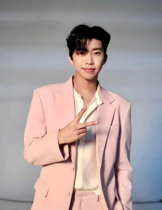임영웅이-핑크색-슈트를-입고-셔츠의-단추를-푼 상태로-오른손으로-브이-표시를-하고-있는-사진