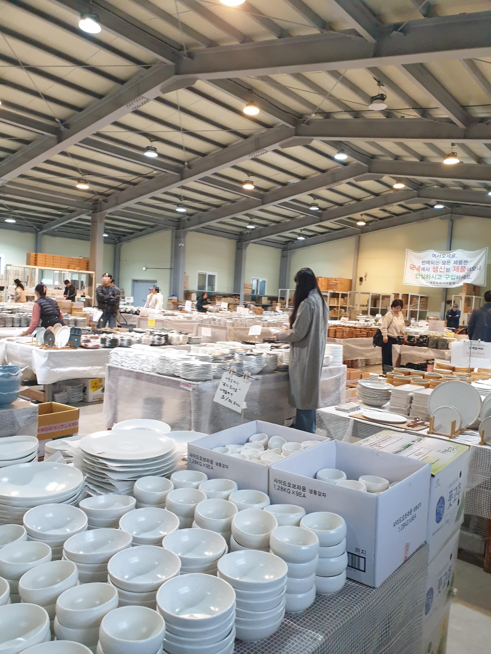 넓은 공간에 테이블로 그릇들이 놓여있다. 동일 할인율 혹은 동일 가격을 묶어 테이블에 세팅