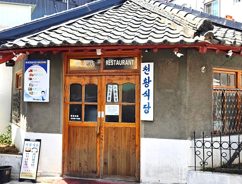 기와 지붕에 나무로 된 문이 있는 오랜 고택 느낌의 진주비빔밥 원조 맛집 천황식당의 외관
