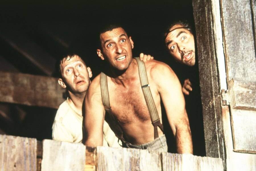 세 남자가 놀란 눈빛으로 숨어서 어딘가를 바라보고 있는 모습