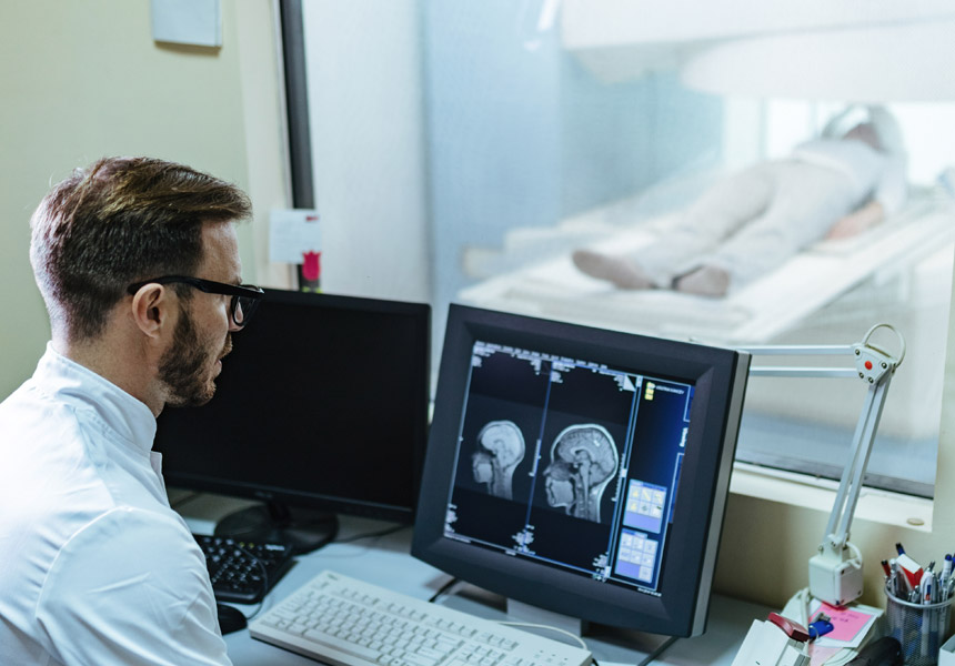 병원에서 환자가 MRI 촬영을 받으며 의료진이 의료 영상을 확인하는 모습
