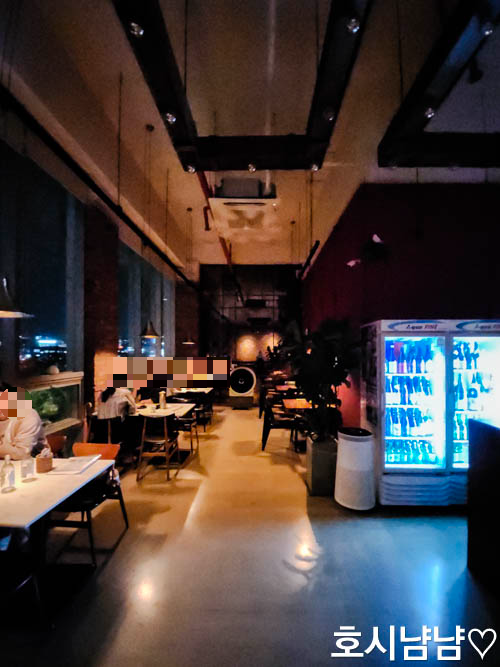 손님들로 붐비는 카멜레온 다이닝 내부 전경과 창가 자리