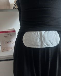 검정옷을-입은-여성이-생리대를-허리에-붙이고있는-약간-코믹한-사진