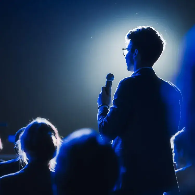 한-남자가-마이크를-들고-연설하고-있는-사진입니다.