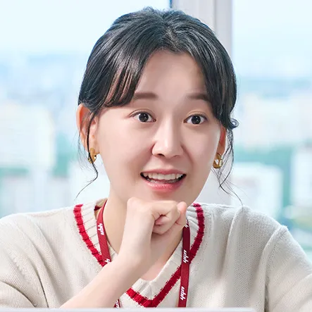 사무실을 배경으로 베이색 티셔츠에 머리를 묶은 무인도의 디바 홍연경